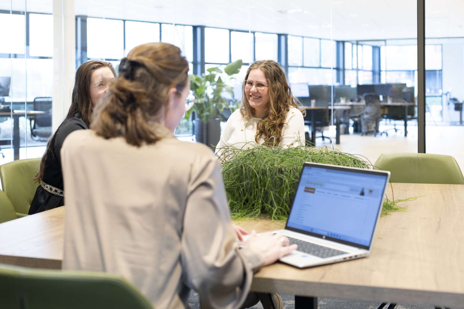 Greengiving-Team bei einer Besprechung am Tisch mit Laptop